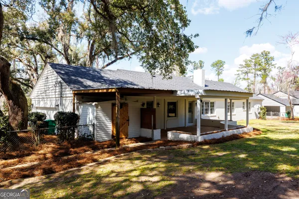 a view of a house with backyard porch and sitting area