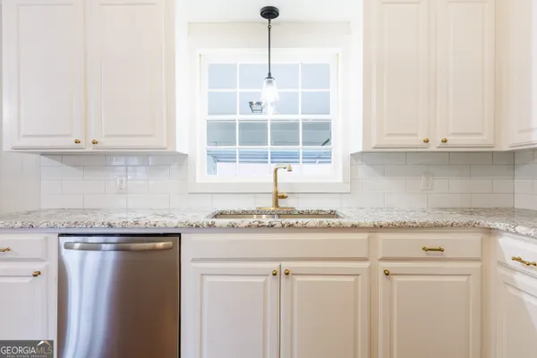 a kitchen with granite countertop cabinets and window