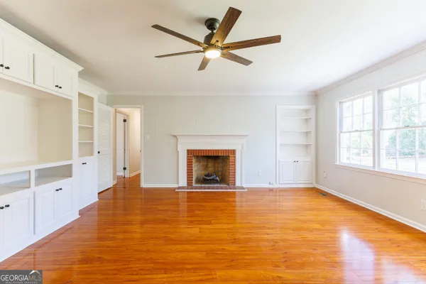 a view of an empty room with a window and fireplace