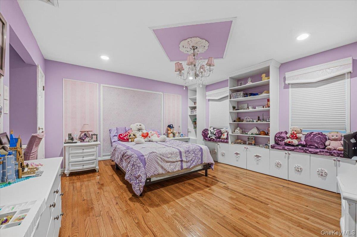 626 Caledonia Road Dix Hills, NY 11746 - Photo 27 of 49 a bedroom with a bed and a chandelier