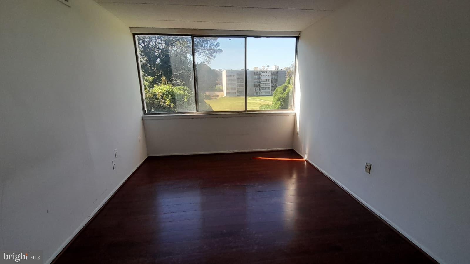 1804 Metzerott Road, Unit 303 Hyattsville, MD 20783 - Photo 7 of 13 an empty room with wooden floor and windows