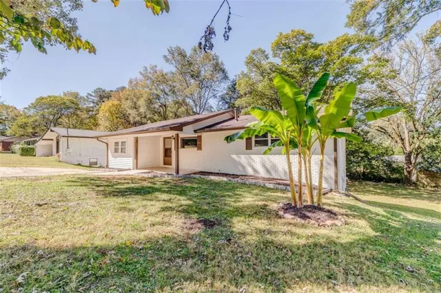 a view of a house with backyard and a tree
