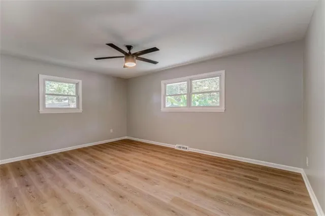 an empty room with a window and a fan