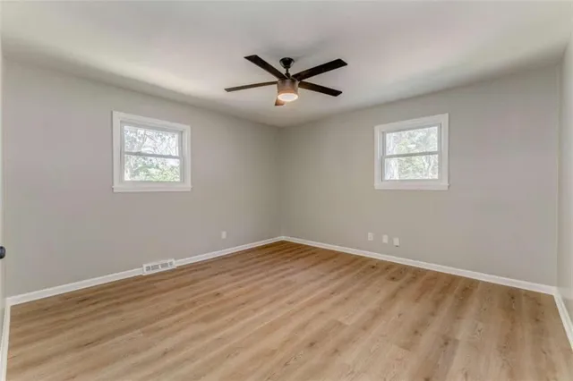 a view of empty room with wooden floor