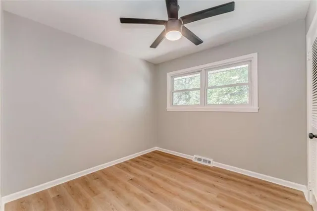 an empty room with wooden floor hallway and closet