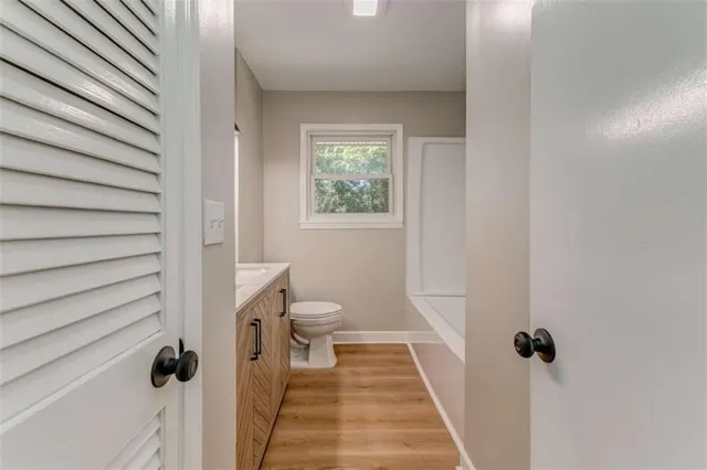 a bathroom with a toilet a sink a mirror and a window