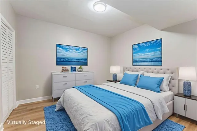a view of an empty room with wooden floor and fan