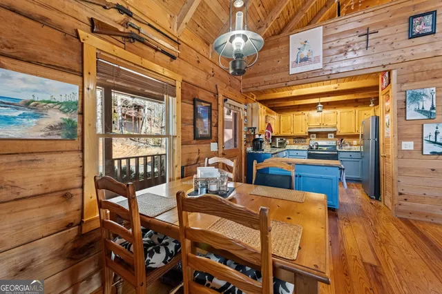 a view of a dining room with furniture a chandelier and wooden floor