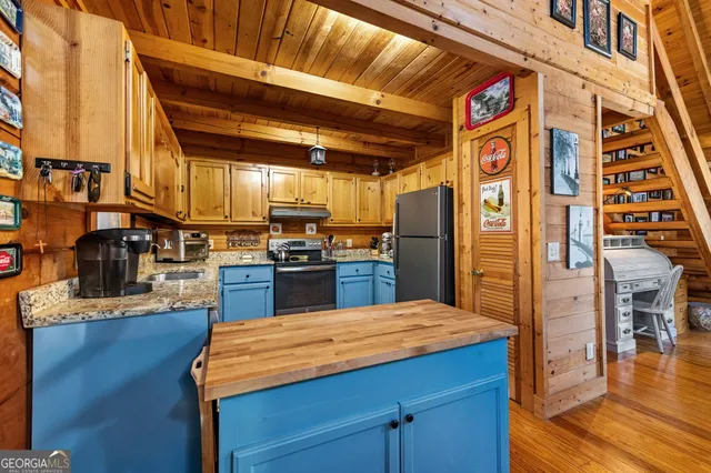 a kitchen with stainless steel appliances kitchen island granite countertop a refrigerator and stove