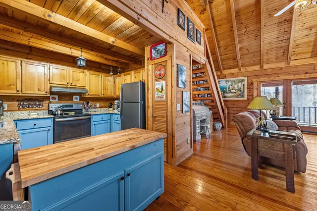 a kitchen with stainless steel appliances kitchen island granite countertop a table chairs and wooden floors