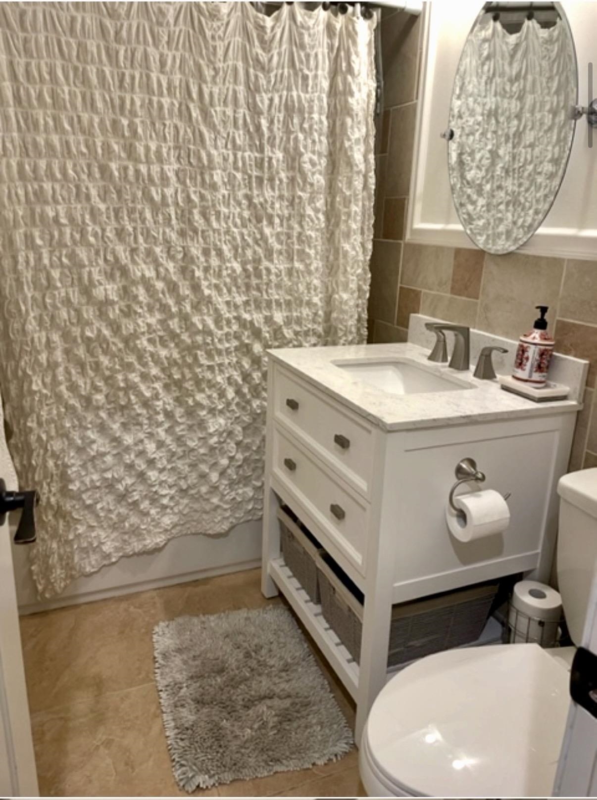 533 Madison Street, Unit 3A Hoboken, NJ 07030 - Photo 8 of 11 a bathroom with a sink a toilet and a shower curtain