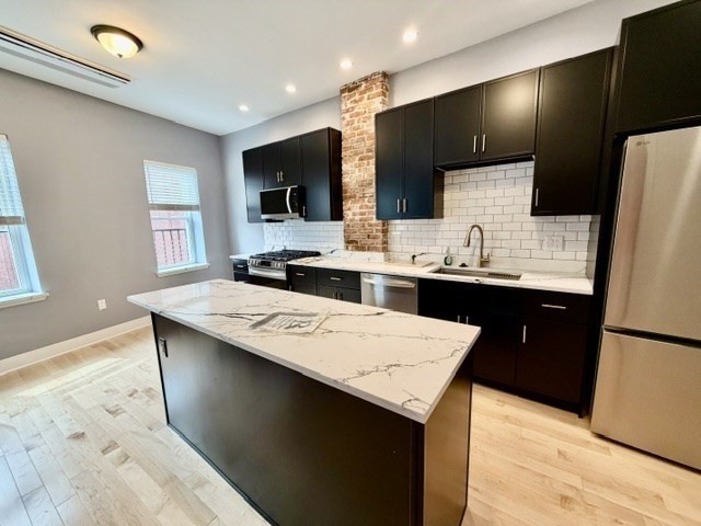 301 North Street, Unit 5 Boston, MA 02113 - Photo 2 of 18 a kitchen with stainless steel appliances kitchen island a sink dishwasher a refrigerator and a microwave
