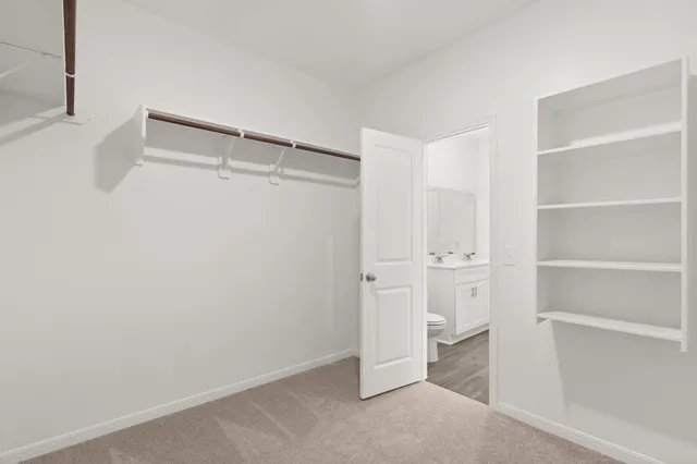 a view of walk in closet with empty racks