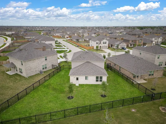 an aerial view of residential houses with outdoor space and ocean view