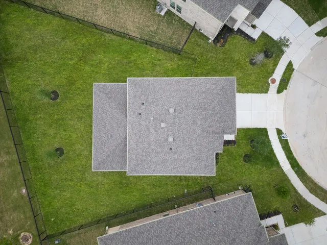 an aerial view of a house with a yard