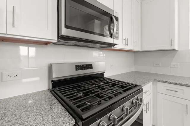 a stove top oven sitting inside of a kitchen