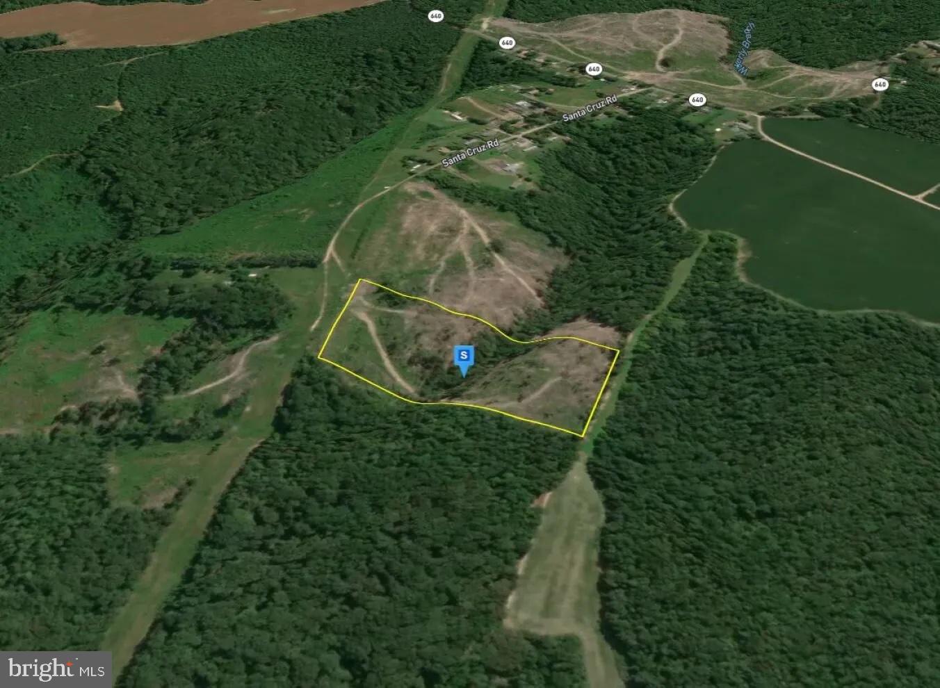 an aerial view of a residential houses with outdoor space and trees