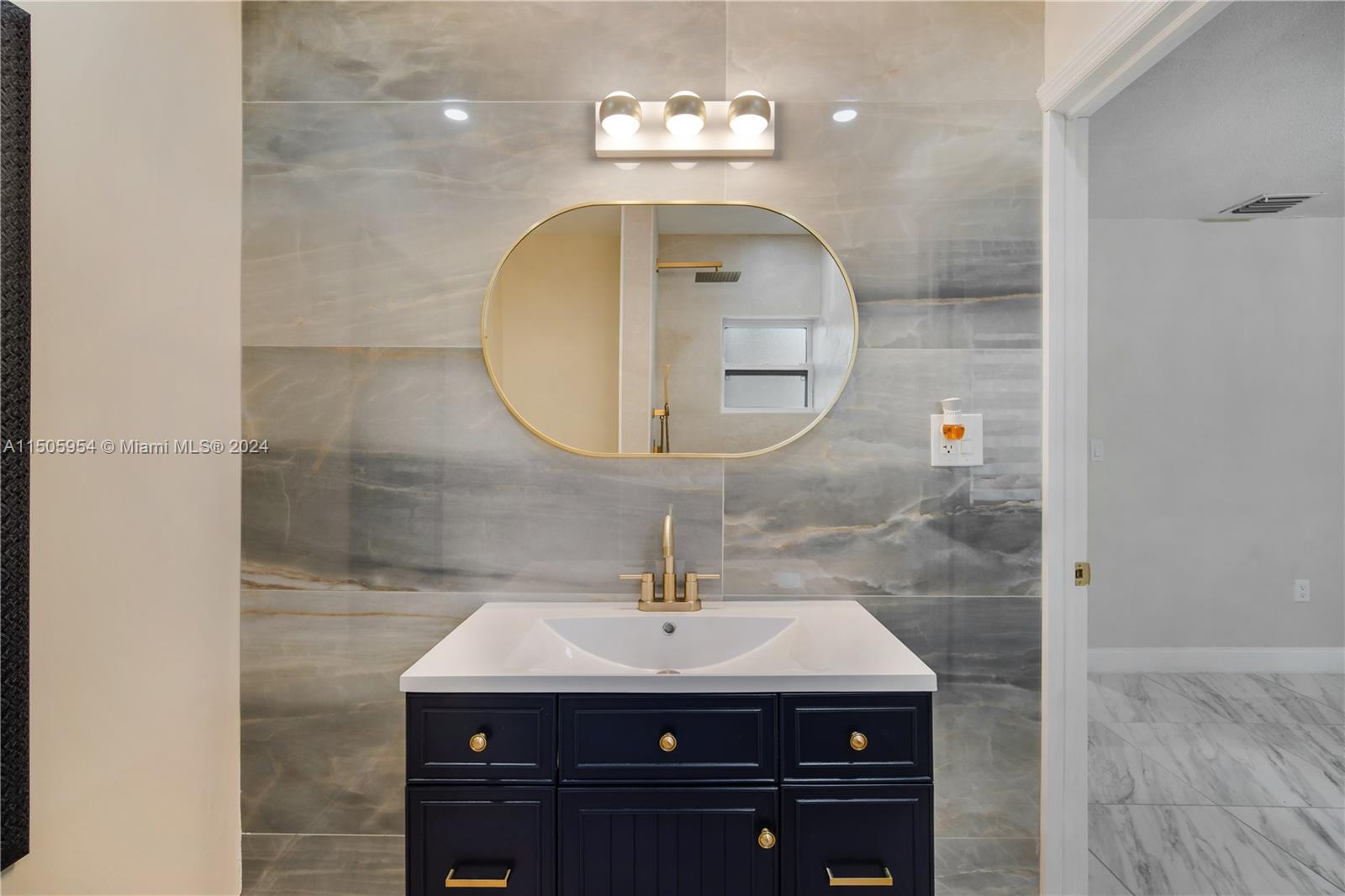 14364 Southwest 159th Terrace Miami, FL 33177 - Photo 25 of 32 a bathroom with a sink a light fixture and a mirror