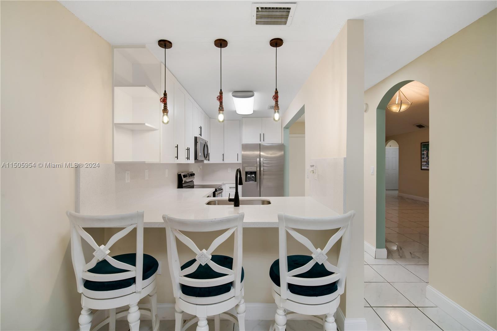 14364 Southwest 159th Terrace Miami, FL 33177 - Photo 10 of 32 a kitchen with a dining table chairs and white cabinets