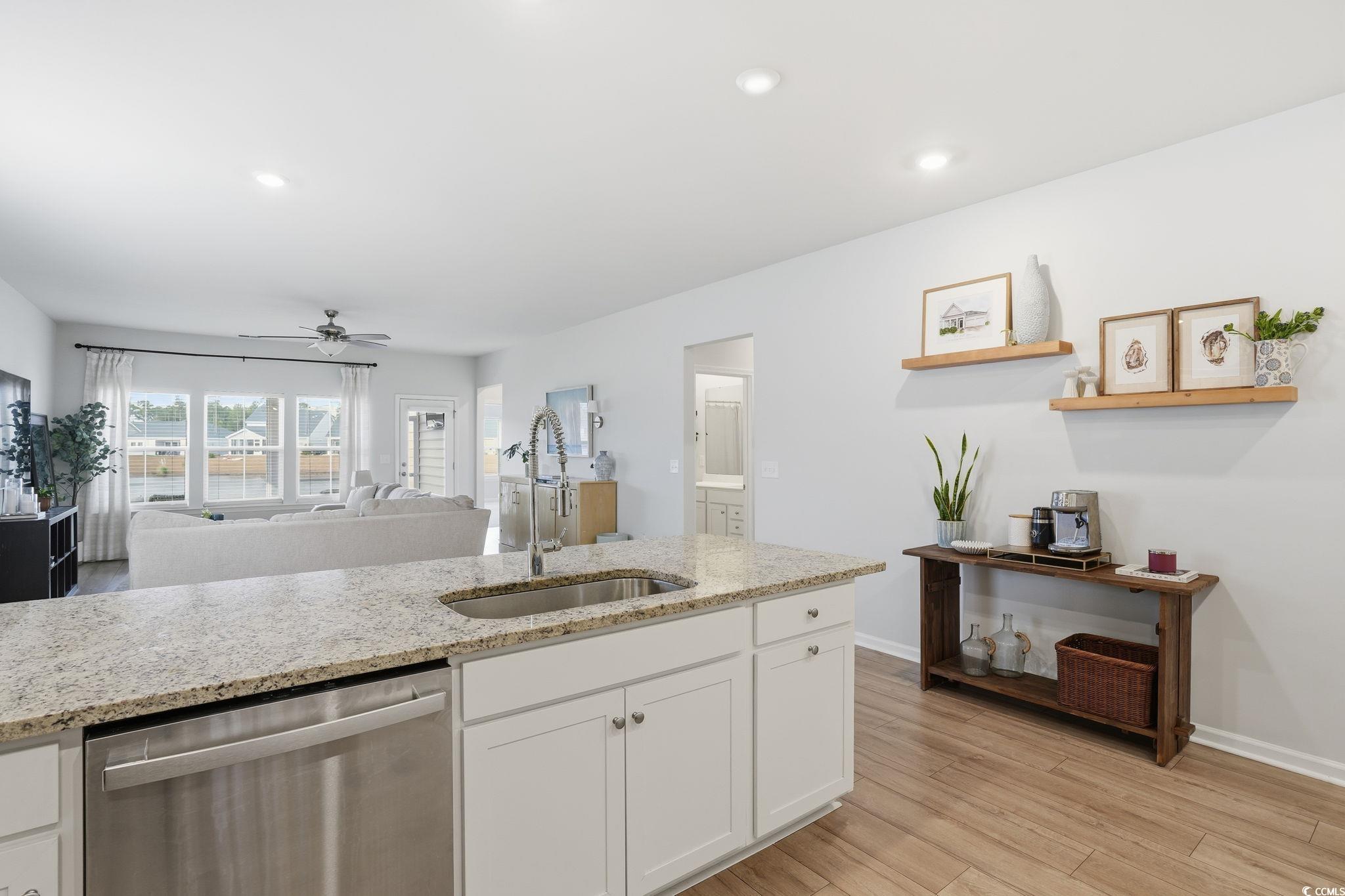 176 Empyrean Circle Myrtle Beach, SC 29588 - Photo 11 of 36 Kitchen with appliances with stainless steel finishes, decorative backsplash, white cabinetry, light stone counters, and light wood-type flooring