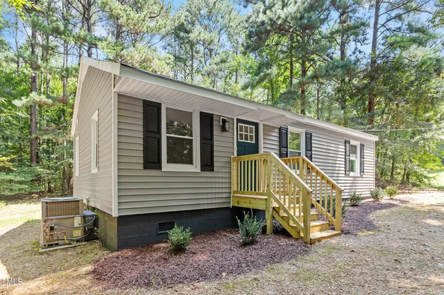 a view of a house with a yard and furniture