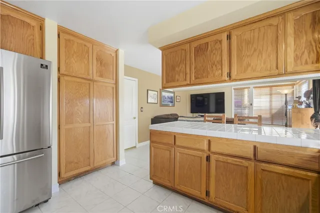a kitchen with kitchen island white cabinets and refrigerator
