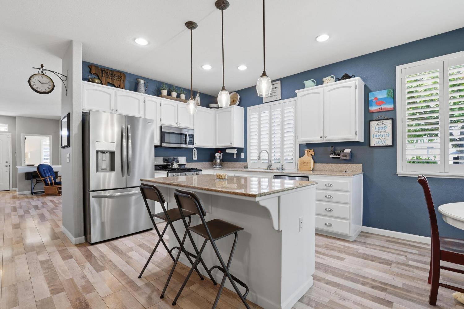 502 Waterfowl Way Williams, CA 95987 - Photo 18 of 51 a kitchen with stainless steel appliances kitchen island granite countertop a refrigerator a stove a sink dishwasher and a refrigerator with wooden floor