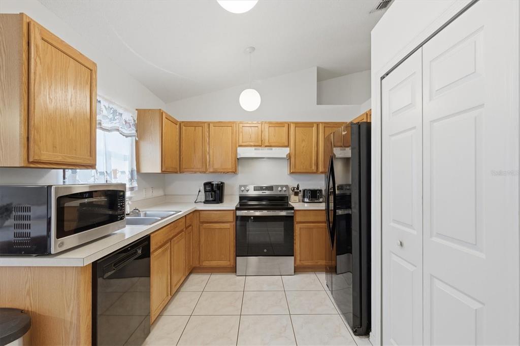 7172 Toledo Road Spring Hill, FL 34606 - Photo 21 of 38 a kitchen with stainless steel appliances granite countertop a stove a sink and a refrigerator