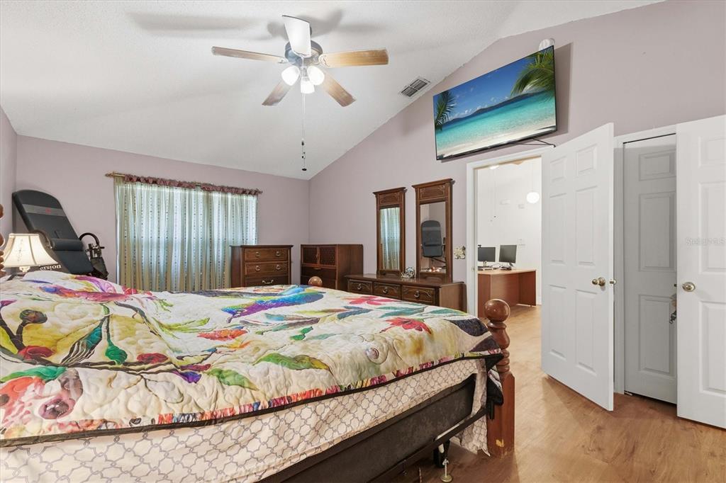 7172 Toledo Road Spring Hill, FL 34606 - Photo 30 of 38 a bedroom with a bed a dresser and wooden floor