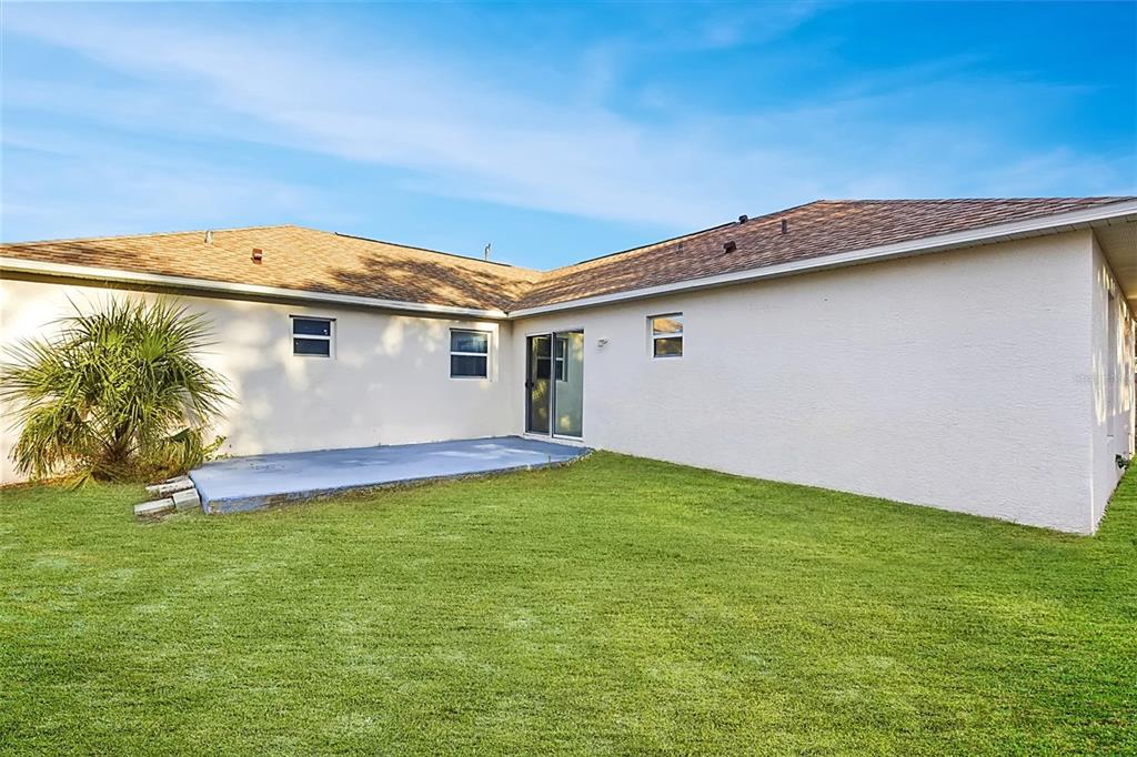 7172 Toledo Road Spring Hill, FL 34606 - Photo 37 of 38 a backyard of a house with plants and palm trees