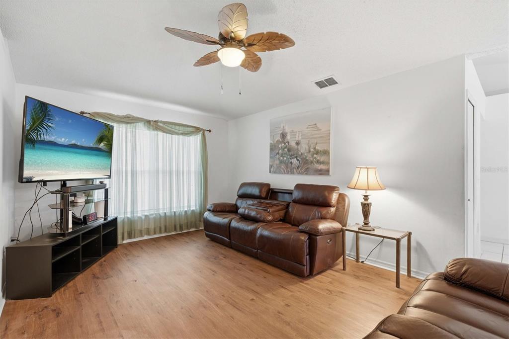 7172 Toledo Road Spring Hill, FL 34606 - Photo 5 of 38 a living room with furniture and a flat screen tv