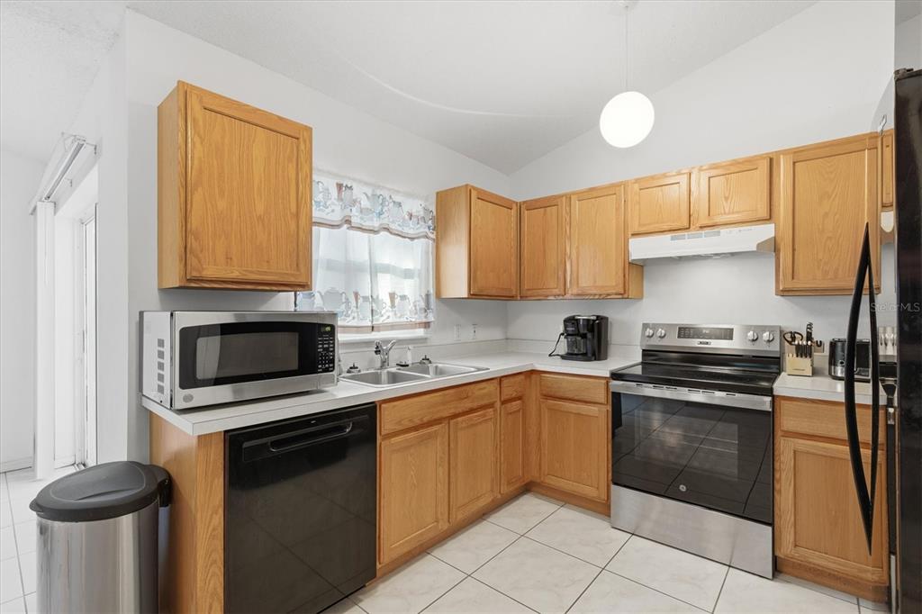 7172 Toledo Road Spring Hill, FL 34606 - Photo 6 of 38 a kitchen with granite countertop a sink cabinets and stainless steel appliances