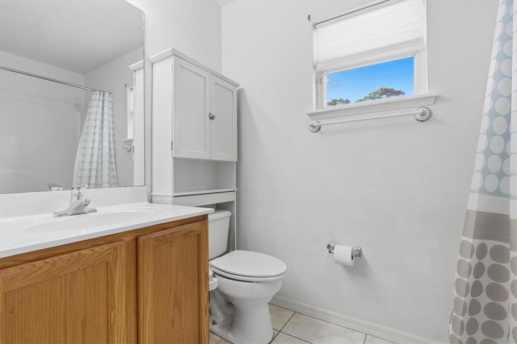 7172 Toledo Road Spring Hill, FL 34606 - Photo 8 of 38 a bathroom with a granite countertop toilet sink and mirror