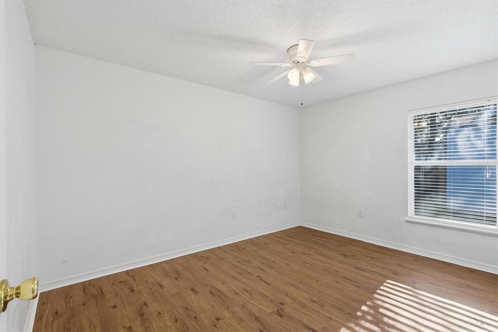7172 Toledo Road Spring Hill, FL 34606 - Photo 10 of 38 wooden floor in an empty room with a window