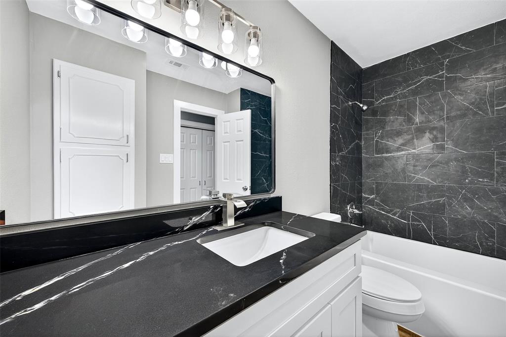 3014 Jennifer Avenue Denison, TX 75020 - Photo 12 of 23 a bathroom with a sink a toilet a mirror and bathtub