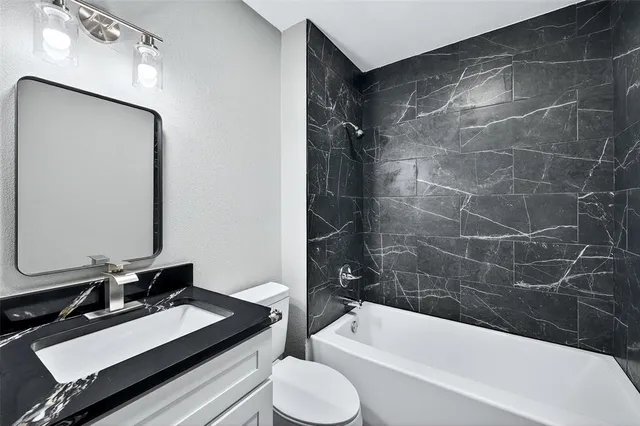 a bathroom with a bathtub shower sink and toilet