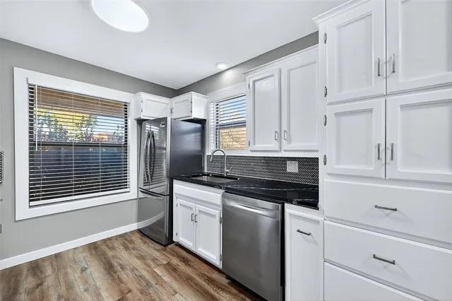 a kitchen with white cabinets and appliances