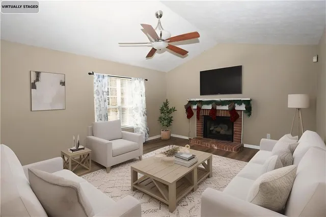 a living room with furniture a flat screen tv and a fireplace