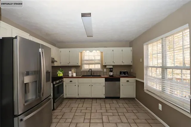 a kitchen with stainless steel appliances granite countertop a stove sink and refrigerator