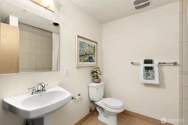 a bathroom with a sink mirror and toilet