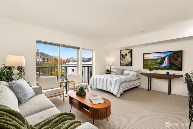 a living room with furniture a flat screen tv and a large window