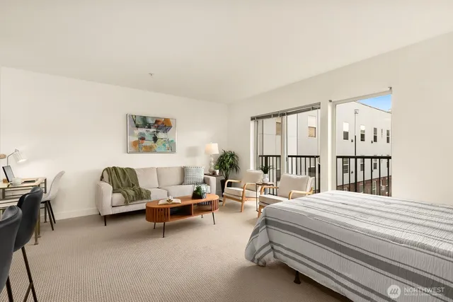 a bedroom with a bed a table and a large window