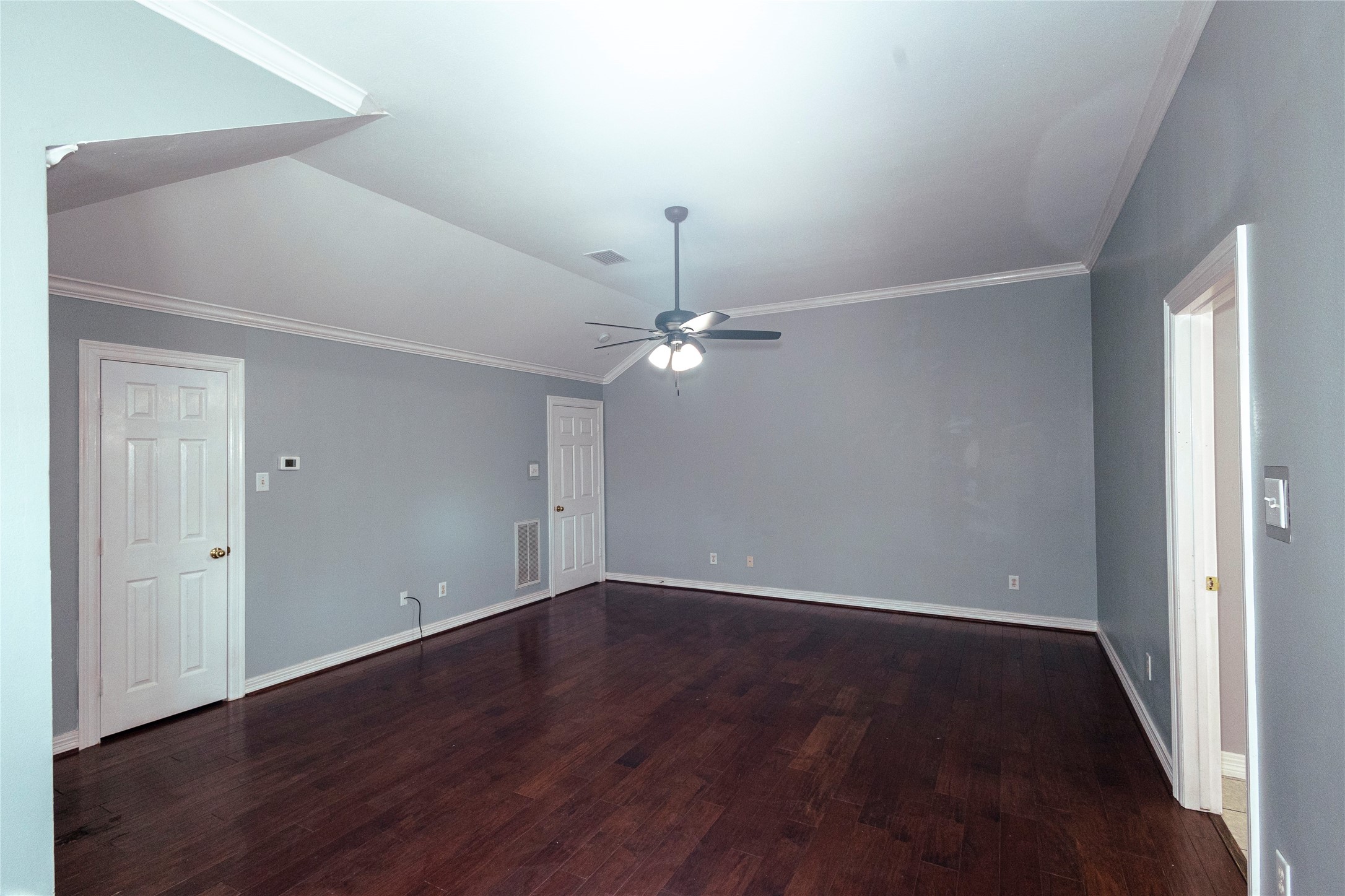4402 Prince Pine Trail Houston, TX 77059 - Photo 12 of 23 an empty room with wooden floor chandelier fan and windows