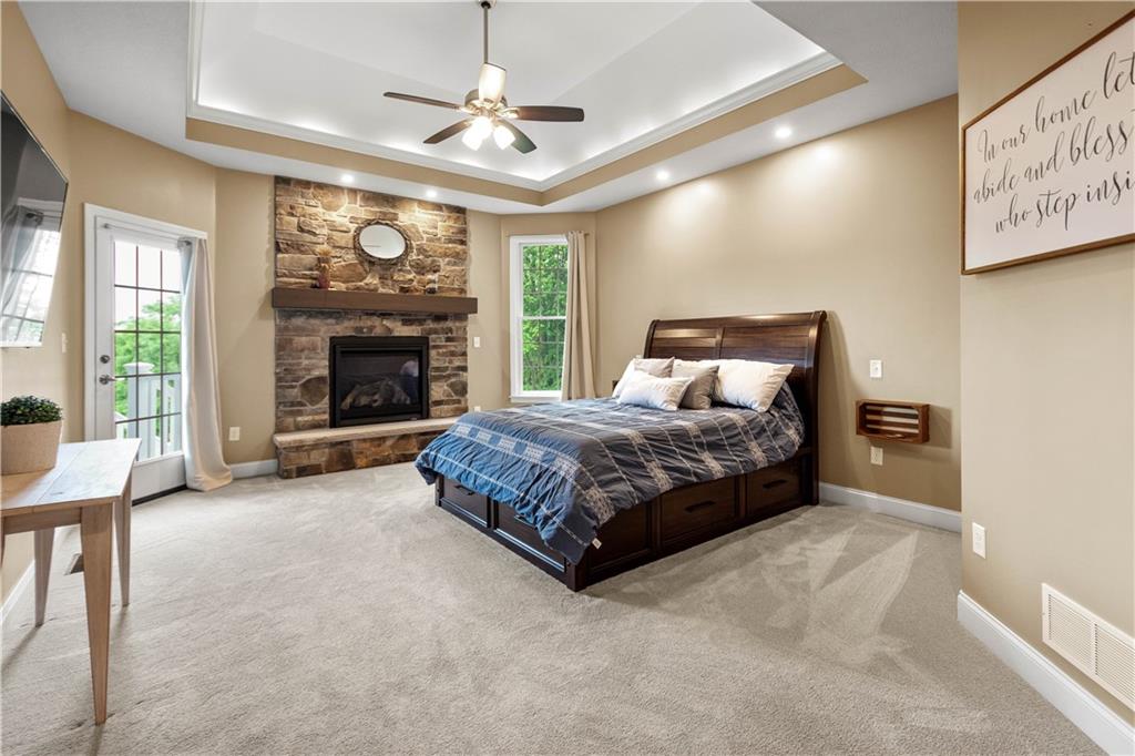 1272 McEwen Road Canonsburg, PA 15317 - Photo 19 of 50 A luxurious master suite with the second gasfireplace, expansive windows offering serene viewsand a patio door leading to the large covered deck