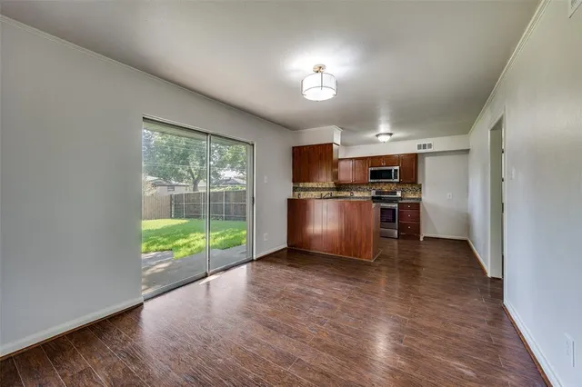 a view of kitchen with wooden floor electronic appliances and windows