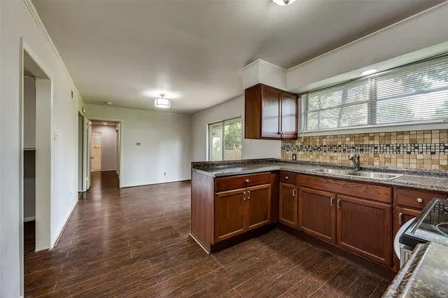 a kitchen with stainless steel appliances granite countertop a sink and wooden cabinets