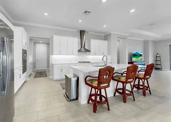 a kitchen with stainless steel appliances granite countertop a table and chairs in it