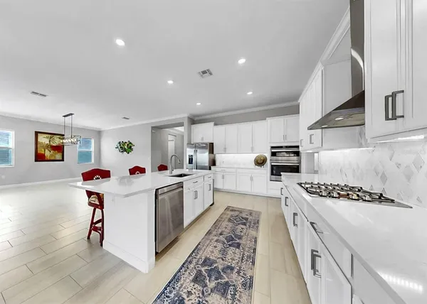 a kitchen with stainless steel appliances white cabinets and a refrigerator