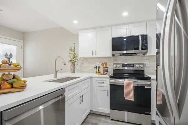 a kitchen with stainless steel appliances granite countertop a sink and dishwasher a refrigerator with wooden cabinets