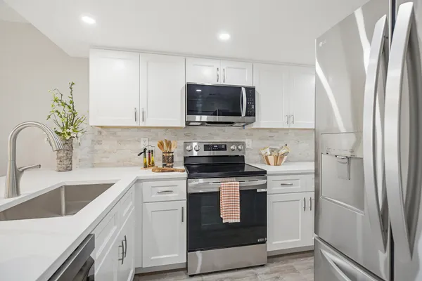 a view of a kitchen with kitchen island a sink and a large window